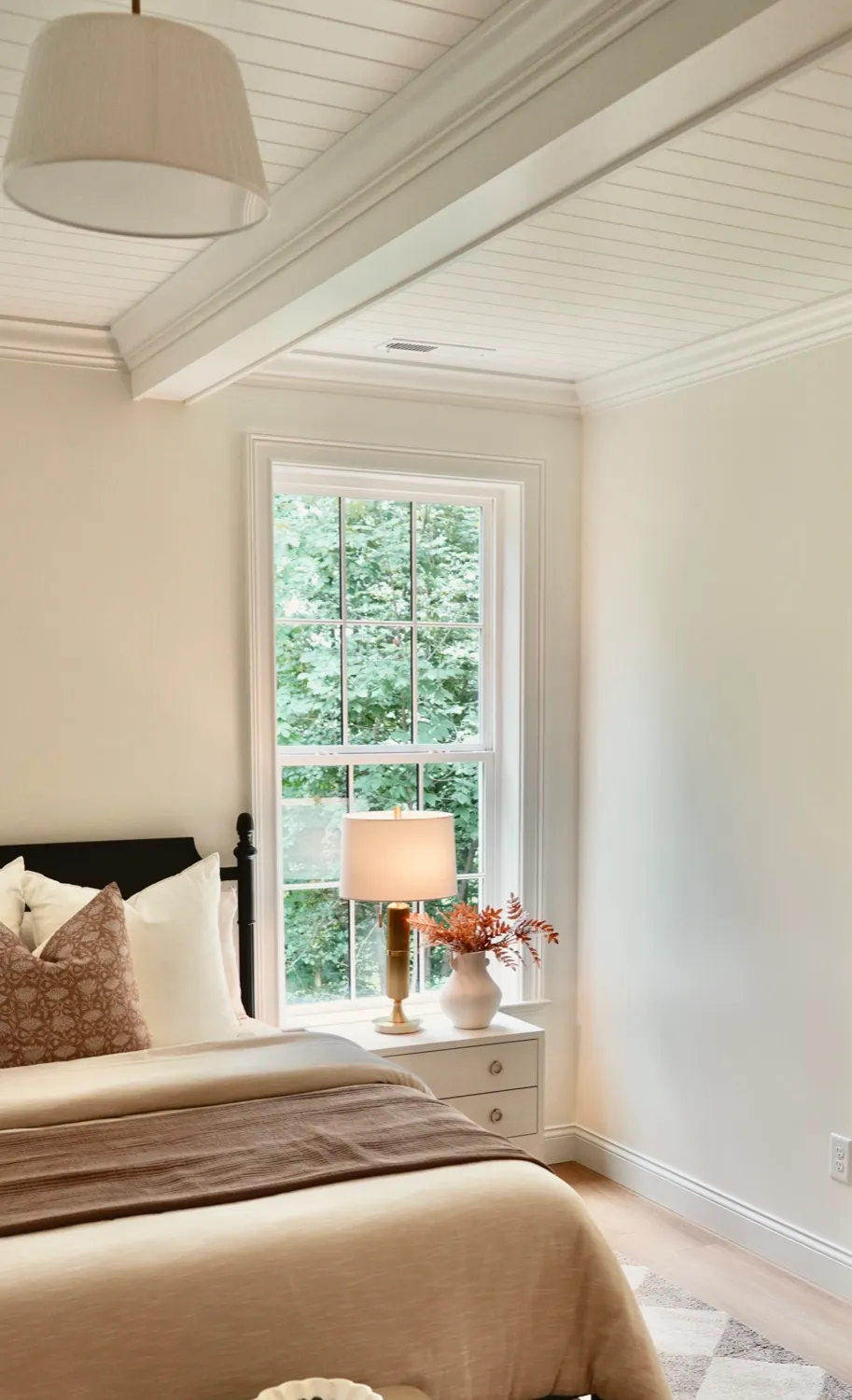 Bedroom with a beamed shiplap ceiling and a tall double-hung window